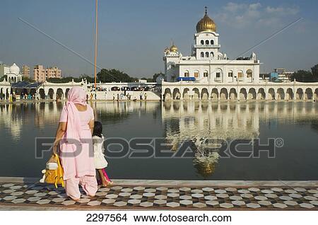 Picture - Mother and child at the Gurudwara Bangla Sahib, a Sikh place of worship in Delhi. Gurudwara Bangla Sahib is the most prominent Sikh gurdwara in Delhi. The temple has a fine golden cupola and a sacred pool of water known as the Saroyar. The holy shrine. Fotosearch