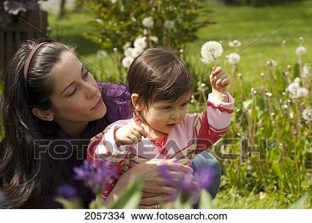 Picture - Mother And Child Looking At Flowers Outside In A Garden, Vancouver British Columbia. Fotosearch