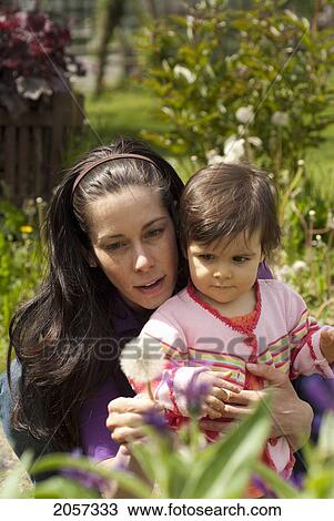 Mother And Child Looking At Flowers Outside In A Garden, Vancouver British Columbia View Large Photo Image Stock Image - Mother And Child Looking At Flowers Outside In A Garden, Vancouver British Columbia. Fotosearch