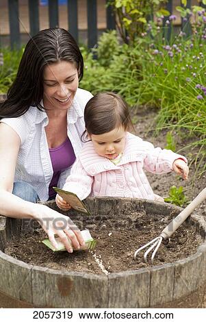 Mother And Child Planting Seeds In Garden Outside, Vancouver British Columbia View Large Photo Image Stock Photo - Mother And Child Planting Seeds In Garden Outside, Vancouver British Columbia. Fotosearch