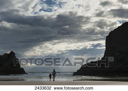 Stock Image - Mother and daughter on beach at Bedruthan Steps; Cornwall, England. Fotosearch