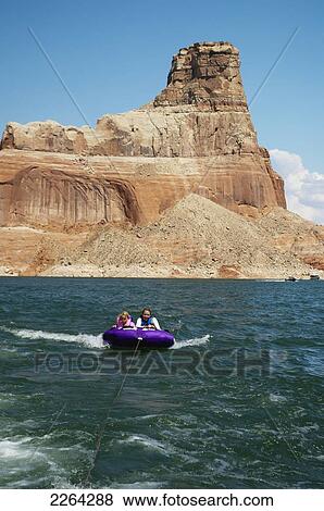 Mother and daughter ride on purple towable tube behind speedboat on lake powell; page arizona usa View Large Photo Image Stock Photo - Mother and daughter ride on purple towable tube behind speedboat on lake powell; page arizona usa. Fotosearch