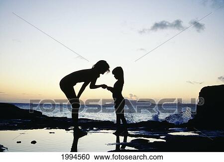 Mother And Daughter Silhouetted In Tidepool At Sunset View Large Photo Image Stock Image - Mother And Daughter Silhouetted In Tidepool At Sunset. Fotosearch
