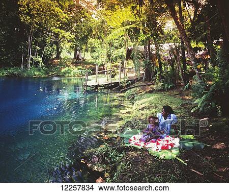 Mother and daughter sit beside a blue hole; Efate Island, Vanuatu View Large Photo Image Picture - Mother and daughter sit beside a blue hole; Efate Island, Vanuatu. Fotosearch