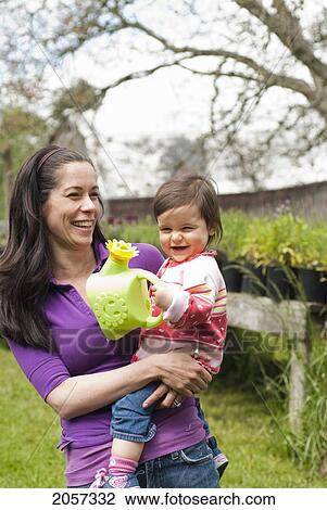 Mother And Daughter With Watering Can In Outside Garden, Vancouver British Columbia View Large Photo Image Stock Image - Mother And Daughter With Watering Can In Outside Garden, Vancouver British Columbia. Fotosearch