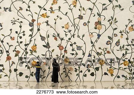 Stock Image - Mother and son in front of decorated wall in the Sheikh Zayed Grand Mosque; Abu Dhabi, United Arab Emirates. Fotosearch