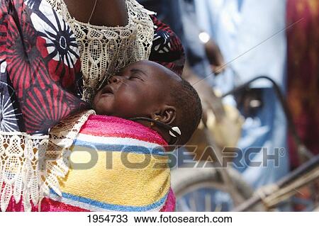 Mother carrying baby on back in Djenne, Mali View Large Photo Image Stock Image - Mother carrying baby on back in Djenne, Mali. Fotosearch