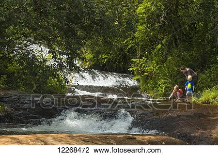 Stock Image - Mother with boy and girl beside small waterfalls, Zomba plateau; Malawi. Fotosearch