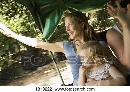 Stock Image - Mother With Daughter Waving Goodbye In Back Of Jeep. Fotosearch