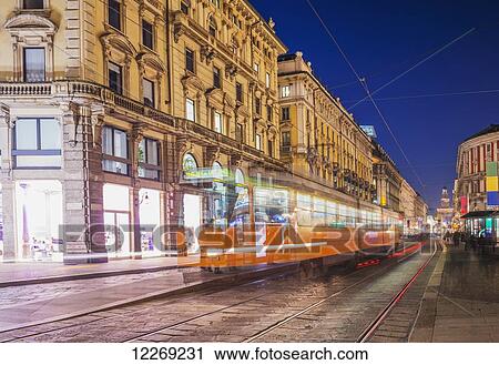 Stock Image - Motion blur of the tram traveling down the street; Milan, Lombardy, Italy. Fotosearch