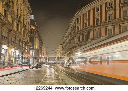 Picture - Motion blur of tram on street at nighttime; Milan, Lombardy, Italy. Fotosearch