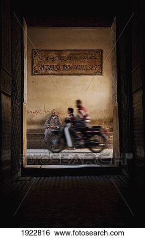 Stock Photograph - Motorbike Passing Entrance Of Ali Ben Youssef Medersa, Marrakesh, Morocco. Fotosearch