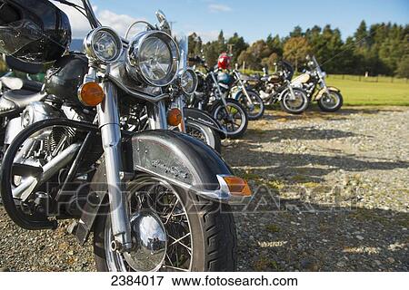 Stock Photo - Motorbikes with helmets parked in a row; Te Anau, South Island, New Zealand. Fotosearch