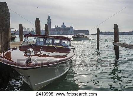 Stock Photo - Motorboats in the Grand Canal with buildings along the shoreline in the distance; Venice, Veneto, Italy. Fotosearch