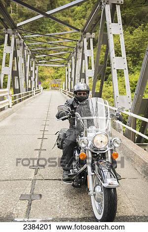Stock Image - Motorcycle touring through Arthurs Pass; South Island, New Zealand. Fotosearch