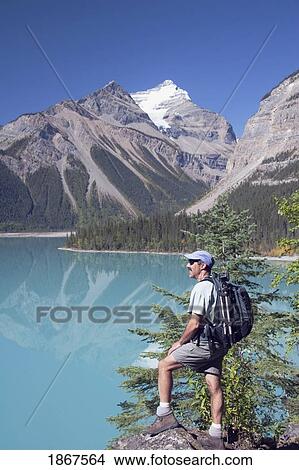 Picture - Mount Robson Provincial Park, British Columbia, Canada; A Hiker Viewing The Mountains And A Mountain Lake. Fotosearch