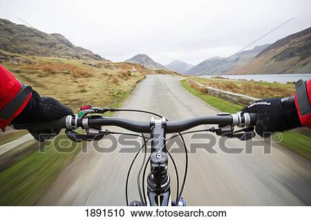 Stock Image - Mountain Biker On Road In Wasdale. Fotosearch