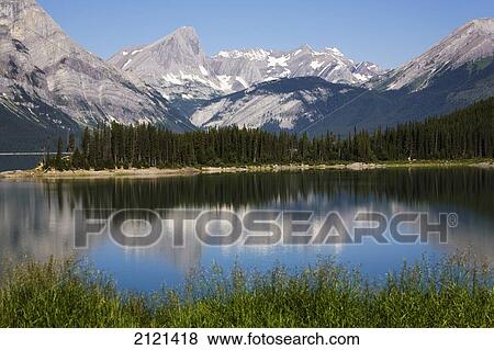 Mountain Lake Reflecting Mountain Range With Snow And Blue Sky; Kananaskis Provincial Park Alberta Canada View Large Photo Image Stock Photo - Mountain Lake Reflecting Mountain Range With Snow And Blue Sky; Kananaskis Provincial Park Alberta Canada. Fotosearch
