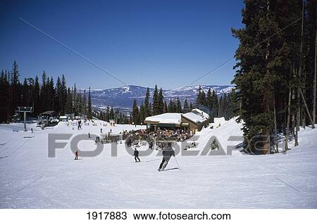 Stock Image - Mountain Restaurant And People Skiing. Fotosearch