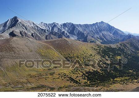 Stock Image - Mountain Valley With Fall Colours And Mountain Range In The Background With Blue Sky; Alberta Canada. Fotosearch