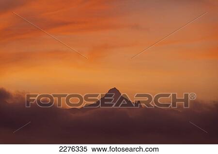 Stock Photography - Mt Kenya coming out from clouds at dawn, Ol Pejeta Conservancy, Kenya.. Fotosearch