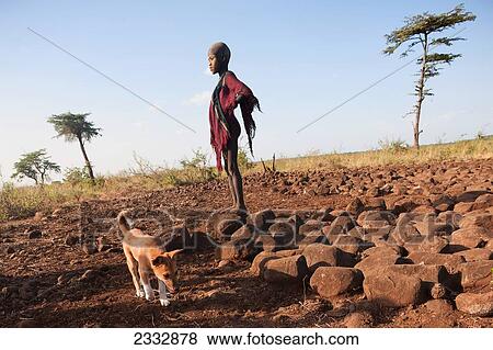 Mursi Boy Standing On Stone Platform Outside Village Of Ulumholi; Dirikoro, Ethiopia View Large Photo Image Stock Photo - Mursi Boy Standing On Stone Platform Outside Village Of Ulumholi; Dirikoro, Ethiopia. Fotosearch