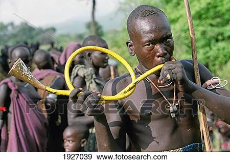Stock Photo - Mursi Tribal Man Blowing Trumpet During Thagine Ceremonial Dueling. Fotosearch