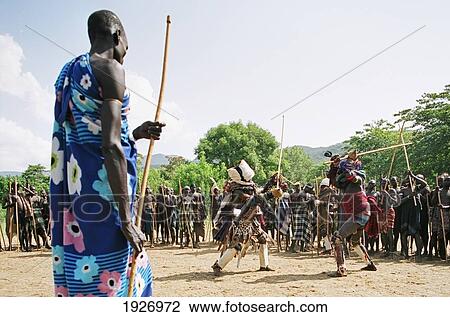 Stock Image - Mursi Tribal Man With Donga Dueling Pole And Tumoga Dueling Kit During Thagine Ceremonial Dueling. Fotosearch
