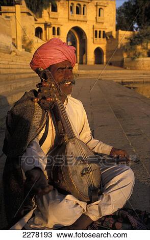 Musician playing traditional stringed instrument, Gadi Sagar Tank; Jaisalmer, India View Large Photo Image Stock Image - Musician playing traditional stringed instrument, Gadi Sagar Tank; Jaisalmer, India. Fotosearch