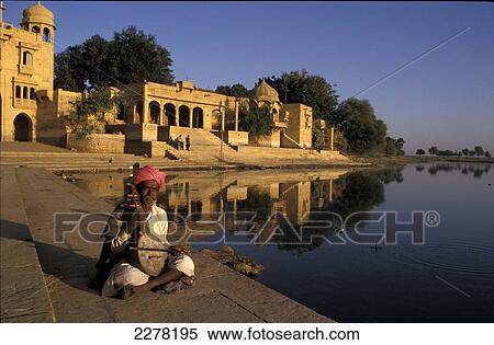 Stock Photography - Musician playing traditional stringed instrument, Gadi Sagar Tank; Jaisalmer, India. Fotosearch