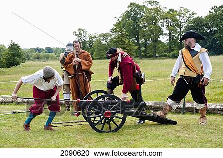 Stock Image - Musketeers Entertaining Tourists In Front Of Lacock Abbey, Lacock, Wiltshire, Uk. Fotosearch