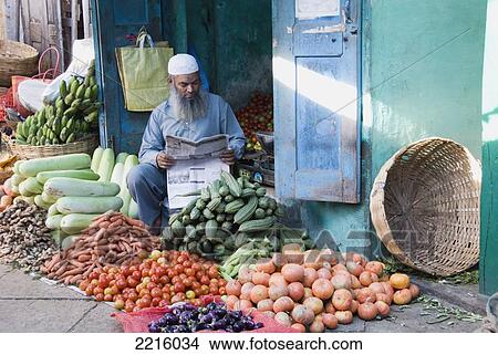 Muslim Vegetable Seller Reading The Newspaper At Devaraja Market In Mysore, Karnataka, India View Large Photo Image Picture - Muslim Vegetable Seller Reading The Newspaper At Devaraja Market In Mysore, Karnataka, India. Fotosearch