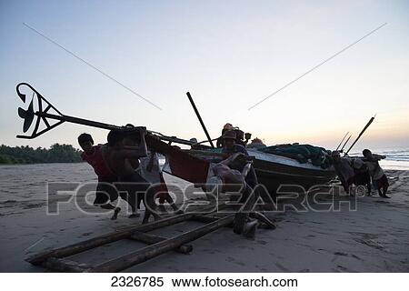 Myanmar (Burma), Irrawaddyi division, Fishermen pulling their boat ashore; Yea Thoe village View Large Photo Image Stock Photography - Myanmar (Burma), Irrawaddyi division, Fishermen pulling their boat ashore; Yea Thoe village. Fotosearch