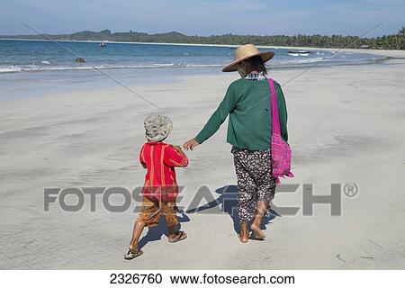 Myanmar, Mother and child walking on beach; Irrawaddyi division View Large Photo Image Stock Image - Myanmar, Mother and child walking on beach; Irrawaddyi division. Fotosearch