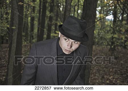 Mysterious young man in a fedora in a park; hartford connecticut usa View Large Photo Image Stock Photo - Mysterious young man in a fedora in a park; hartford connecticut usa. Fotosearch