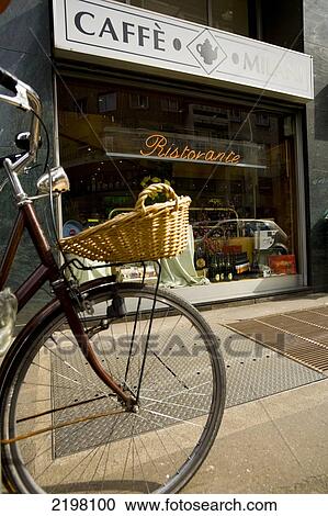 Stock Image - Naki Kouyioumtzis/ Axion Milan, Italy. Cafe Milan, Cycle And Basket. Fotosearch