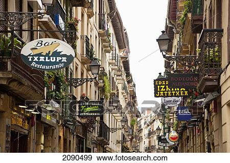 Stock Photo - Narrow Street With Shop Signs In The Old Quarter, San Sebastian, Basque Country, Spain. Fotosearch