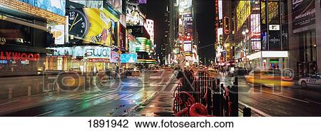 Stock Image - Neon Advertising Hoardings, Tourists And Traffic At Times Square. Fotosearch