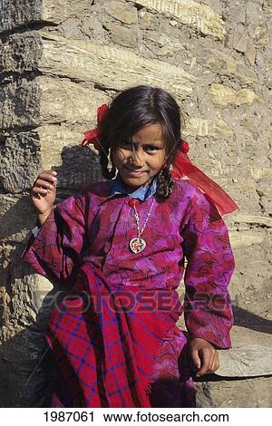 Nepal, Gorkha, Portrait Of Young Village Girl In Colorful Clothing, Standing Against Stone Building. Editorial Use Only. View Large Photo Image Stock Image - Nepal, Gorkha, Portrait Of Young Village Girl In Colorful Clothing, Standing Against Stone Building. Editorial Use Only.. Fotosearch