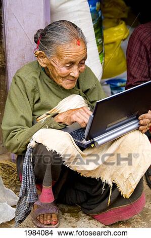 Picture - Nepal, Kathmandu, Bhaktapur, Old Hindu Woman Using A Laptop Computer.. Fotosearch