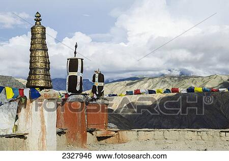 Stock Photograph - Nepal, Upper Mustang, Prayer flags and symbols at top of King's Palace; Lo Manthang. Fotosearch