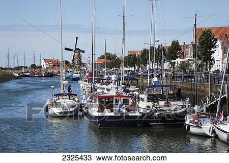 Stock Image - Netherlands, Zealand, Boats in a busy harbor along the waterfront; Zierikzee. Fotosearch
