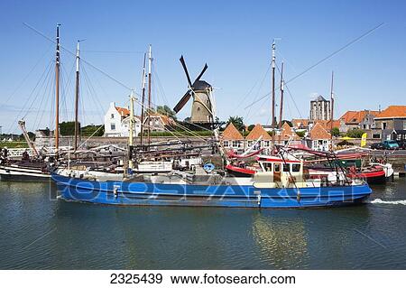 Netherlands, Zealand, Boats in the harbor with a windmill in the background; Zierikzee View Large Photo Image Stock Photo - Netherlands, Zealand, Boats in the harbor with a windmill in the background; Zierikzee. Fotosearch
