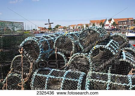 Stock Photograph - Netherlands, Zealand, Fishing traps along the waterfront at the harbor; Zierikzee. Fotosearch