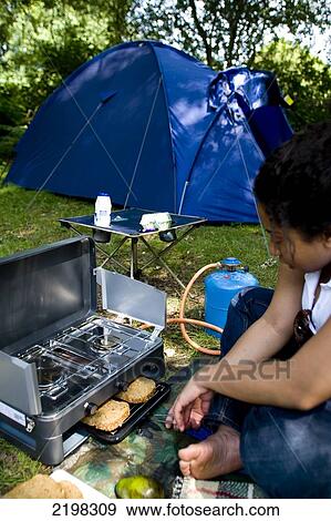 Stock Photo - New Forest, Hampshire, Uk. Cooking On Gas Stove, Camping And Tent. Fotosearch