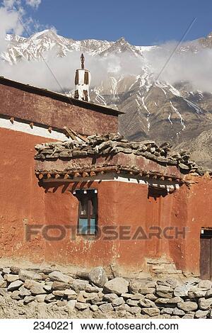 Stock Image - New Geling Gompa (Monastery) Painted Red With Annapurna Peak; Geling, Upper Mustang Valley, Nepal. Fotosearch