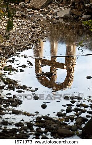 Stock Image - New Mexico, El Sanctuario De Chimayo (Lourdes Of America), Reflection Of Stone Cross In Creek.. Fotosearch