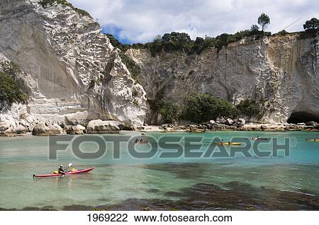Stock Image - New Zealand, North Island, Coromandel, Stingray Cove, Kayakers Paddling In The Ocean.. Fotosearch