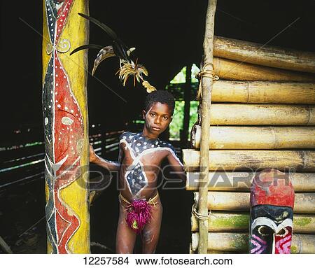 Ni-Vanuatu boy standing in the doorway of traditional men's house; Malekula Island, Vanuatu View Large Photo Image Picture - Ni-Vanuatu boy standing in the doorway of traditional men's house; Malekula Island, Vanuatu. Fotosearch