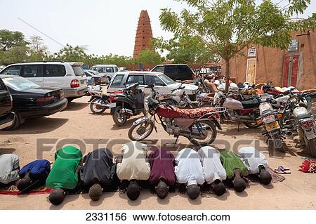 Stock Photograph - Niger, keeping old form intact. Mosque hosts renowed Centre of Islamic Studies. Minaret is tallest mud-bricked minaret in Africa; Agadez, was originally built in 1515 but restored in 1844, made of clay, Friday prayers by Agadez Grand Mosque. Fotosearch